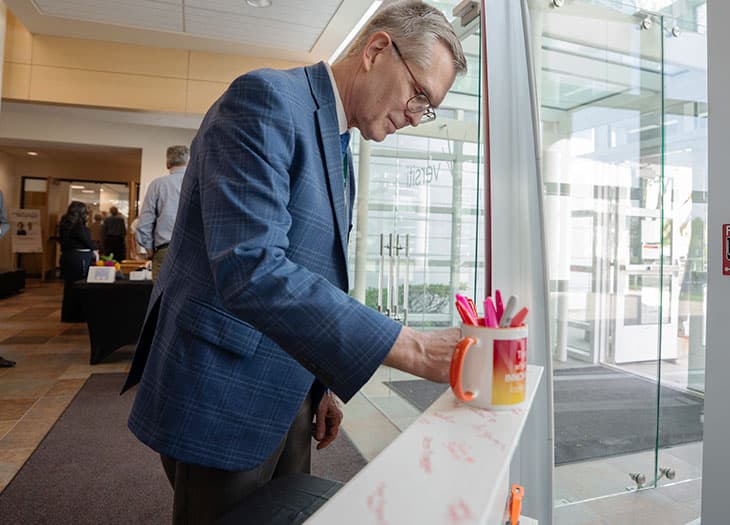 Attendee signing the beam at the VBRI Milestone event.
