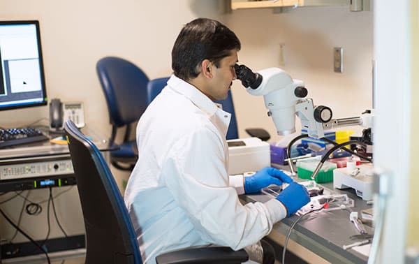 Person looking into a microscope.