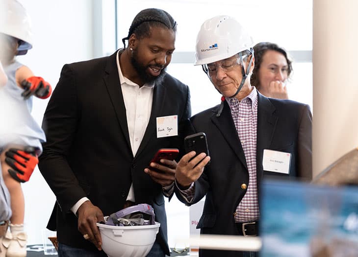 Two event attendees looking at the invest in hope website.