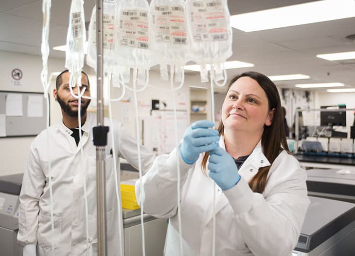 Lab technician with units hanging from a rack.