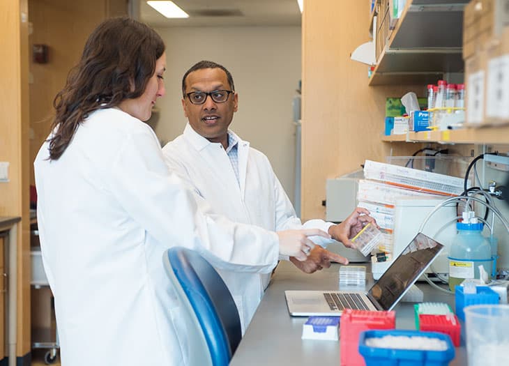 Dr. Sid Rao and a lab team member discussing DNA typing.