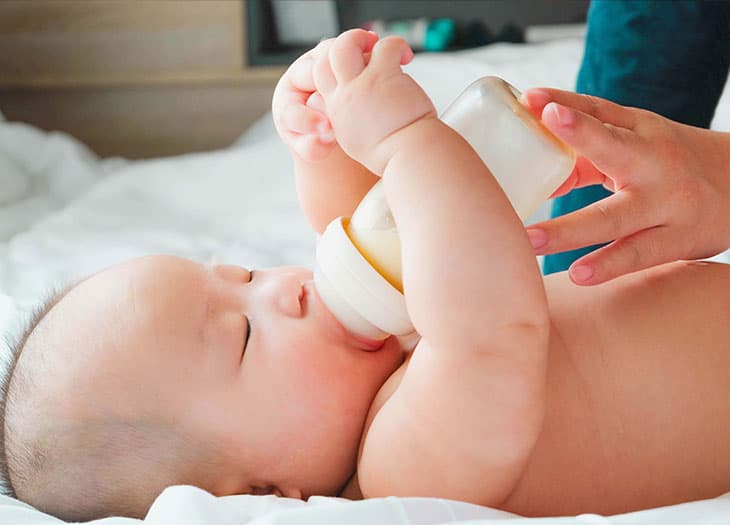 Baby holding a bottle.
