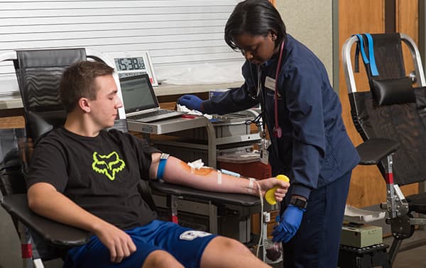 Man giving blood at a mobile blood drive.