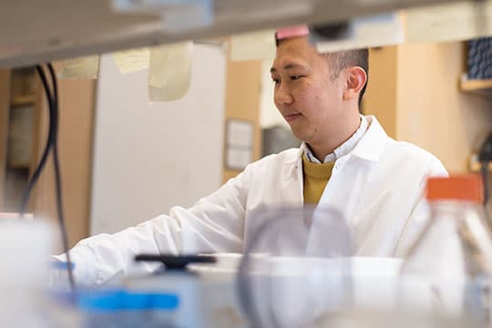 Yongwei, sitting at a lab bench.